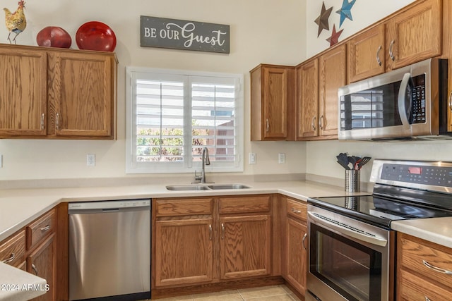 kitchen featuring light tile patterned flooring, stainless steel appliances, and sink