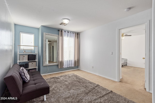 sitting room featuring light carpet and ceiling fan