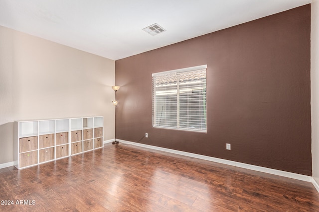 unfurnished room with dark hardwood / wood-style flooring