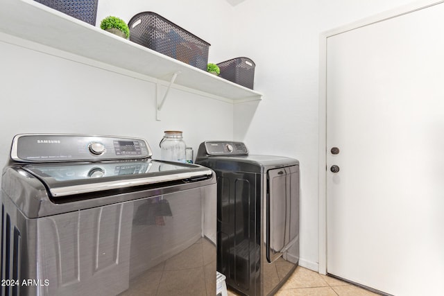 washroom featuring washer and clothes dryer and light tile patterned floors