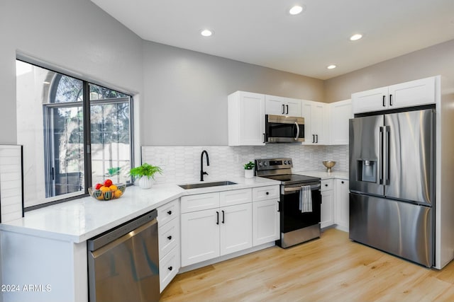 kitchen with appliances with stainless steel finishes, white cabinetry, and sink