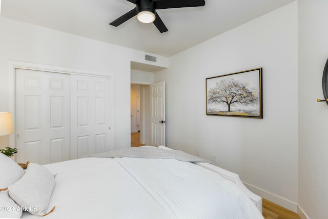 bedroom featuring a closet, light hardwood / wood-style flooring, and ceiling fan