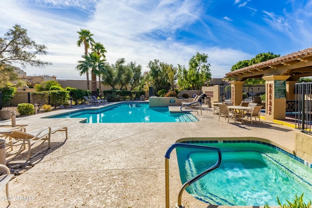 view of swimming pool with a community hot tub and a patio area