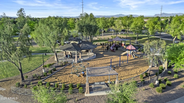 view of community featuring playground community, fence, a gazebo, and a mountain view