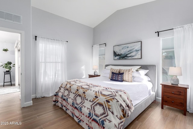 bedroom with high vaulted ceiling and light hardwood / wood-style floors