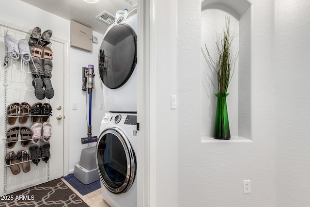 clothes washing area featuring stacked washer / dryer