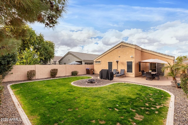 back of property featuring a lawn, a patio area, and an outdoor fire pit