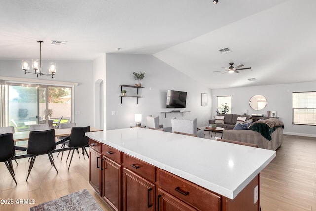 kitchen featuring lofted ceiling, pendant lighting, light hardwood / wood-style flooring, and a center island