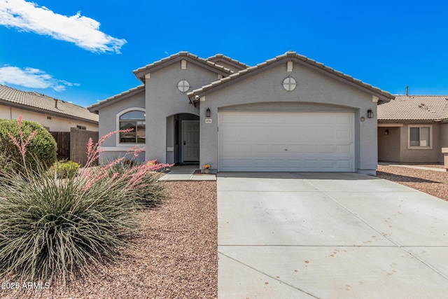 mediterranean / spanish-style house with stucco siding, a tile roof, an attached garage, and driveway