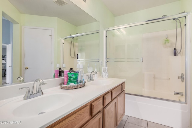 bathroom featuring tile patterned floors, double vanity, and bath / shower combo with glass door