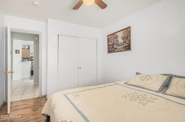 bedroom featuring light wood-type flooring, a closet, and ceiling fan
