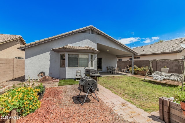 back of house featuring stucco siding, a patio, and a tiled roof