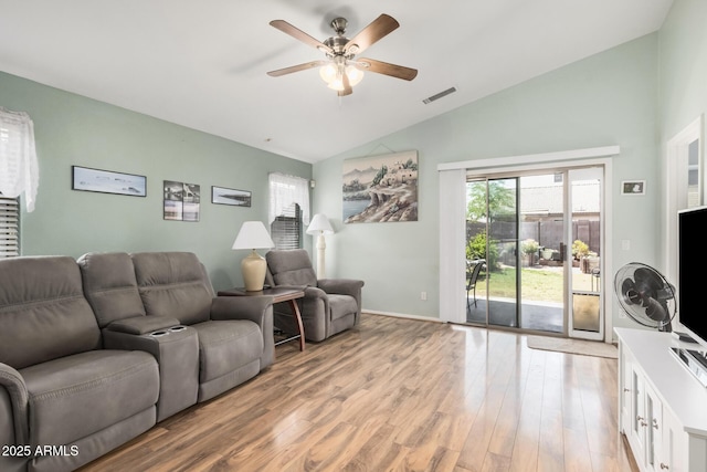 living area featuring vaulted ceiling, a ceiling fan, and light wood-style floors