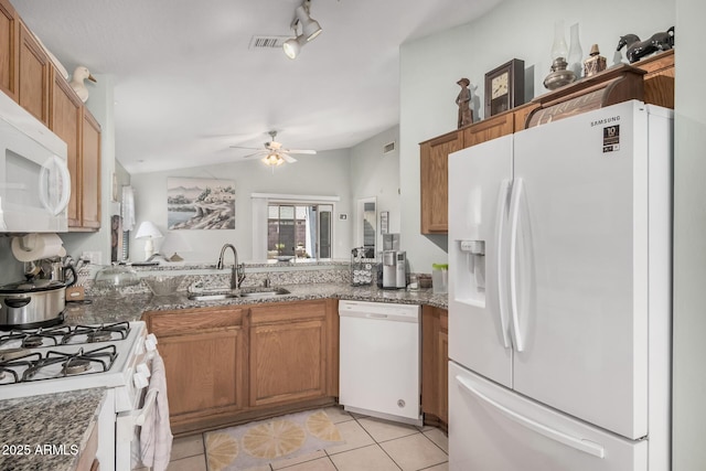 kitchen with white appliances, a sink, vaulted ceiling, light tile patterned floors, and a ceiling fan