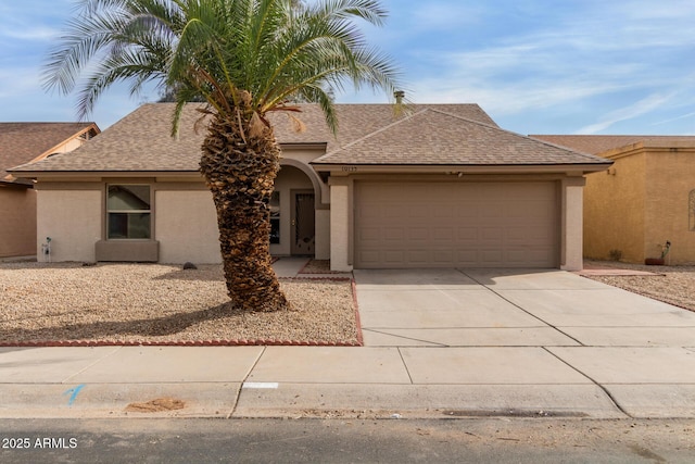 view of front of home featuring concrete driveway, roof with shingles, an attached garage, and stucco siding