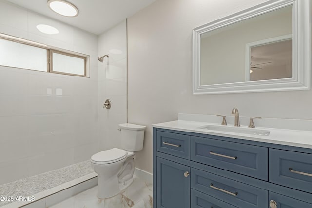 full bathroom featuring toilet, vanity, baseboards, marble finish floor, and a tile shower