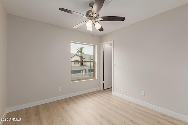 unfurnished room with light wood-type flooring, a ceiling fan, and baseboards