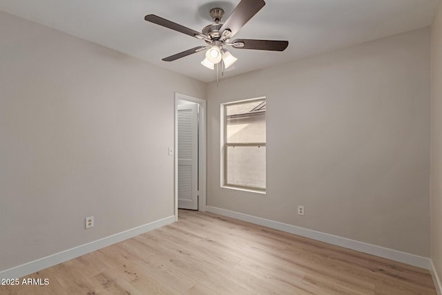 spare room featuring light wood-style flooring, baseboards, and ceiling fan