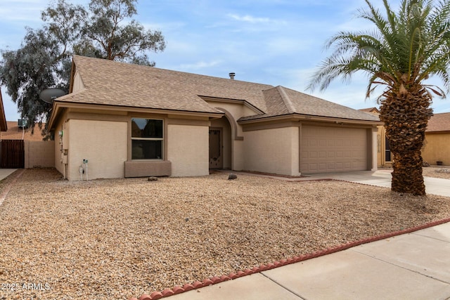 single story home featuring a garage, fence, concrete driveway, roof with shingles, and stucco siding