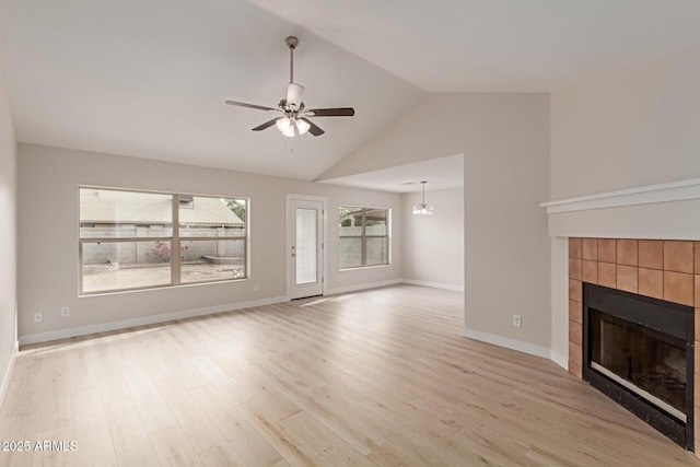 unfurnished living room with light wood finished floors, ceiling fan, baseboards, and a tiled fireplace