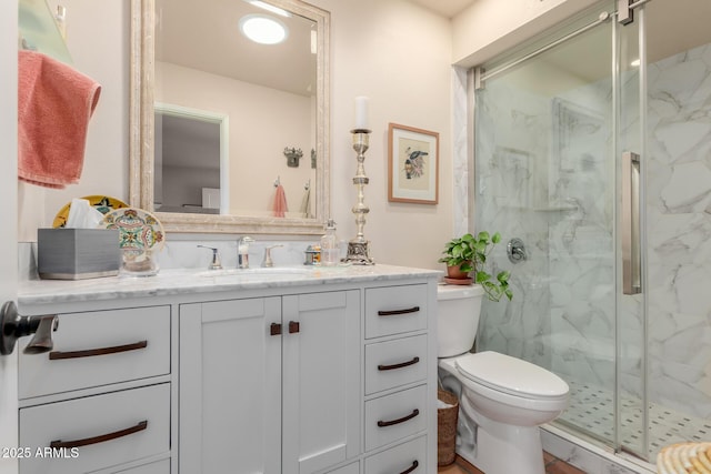 bathroom with vanity, toilet, and a shower with shower door