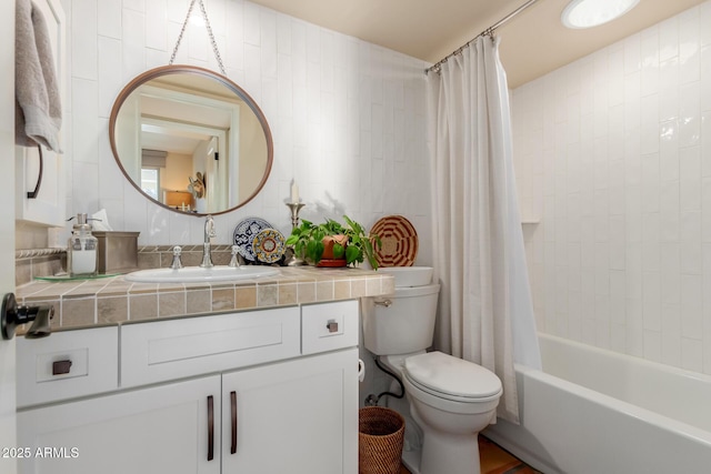 full bathroom featuring vanity, shower / bathtub combination with curtain, toilet, and tile walls