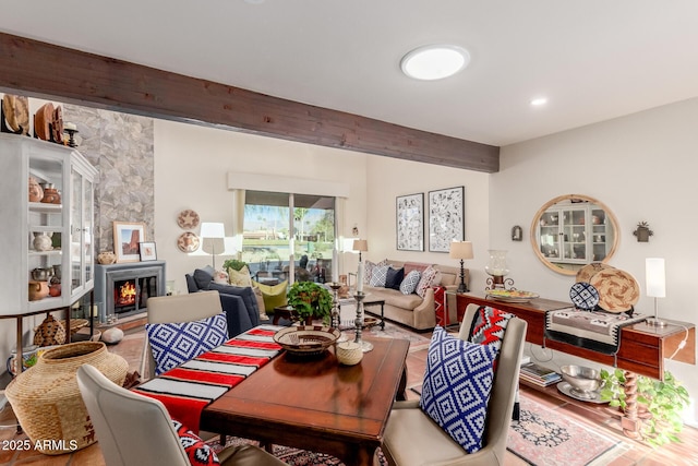 dining area featuring beam ceiling and a large fireplace