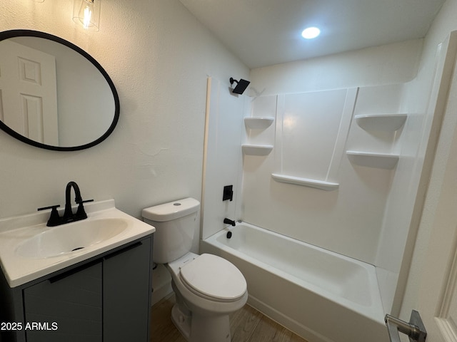 bathroom with toilet, shower / tub combination, wood finished floors, and vanity