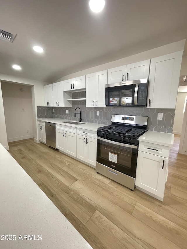 kitchen with light countertops, appliances with stainless steel finishes, a sink, and visible vents