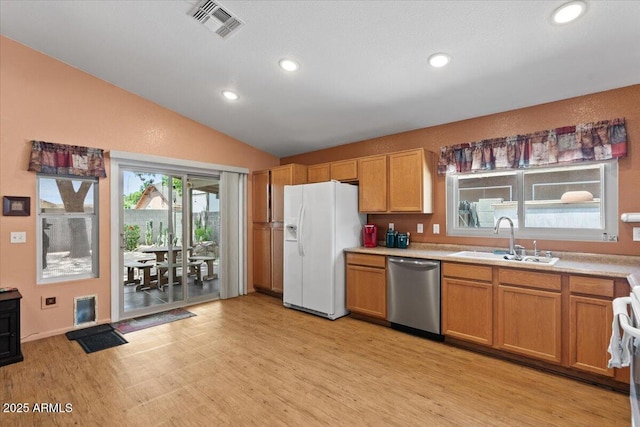 kitchen featuring light wood finished floors, white fridge with ice dispenser, a sink, visible vents, and dishwasher