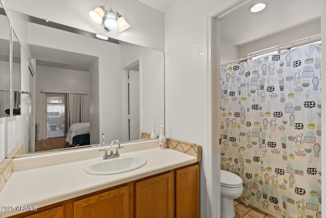 ensuite bathroom featuring connected bathroom, toilet, a shower with curtain, tile patterned flooring, and vanity