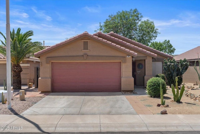 view of front facade with a tile roof, an attached garage, stucco siding, and driveway
