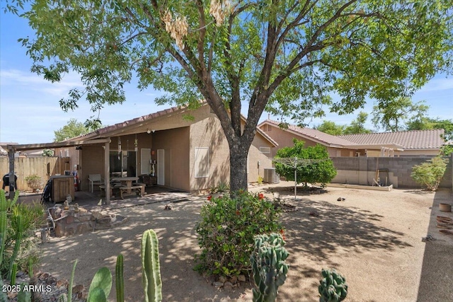 back of property with a tiled roof, stucco siding, fence, and a patio area