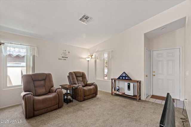 living room featuring vaulted ceiling, light carpet, and visible vents