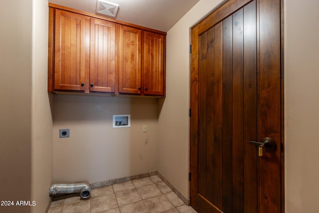 laundry room with hookup for an electric dryer, light tile patterned floors, hookup for a washing machine, and cabinets