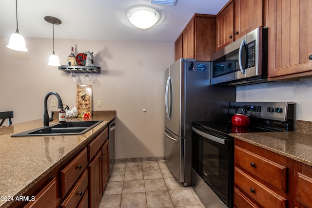 kitchen featuring appliances with stainless steel finishes, stone counters, sink, pendant lighting, and light tile patterned floors