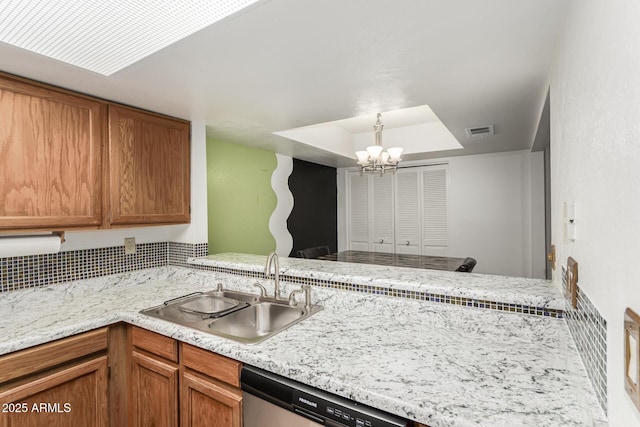 kitchen featuring kitchen peninsula, a notable chandelier, hanging light fixtures, stainless steel dishwasher, and sink