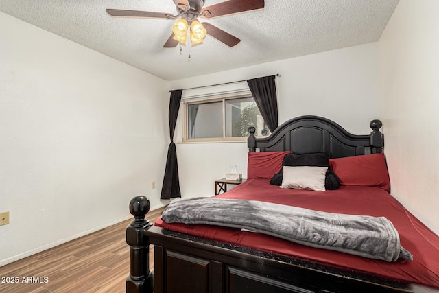 bedroom with ceiling fan, a textured ceiling, and hardwood / wood-style flooring