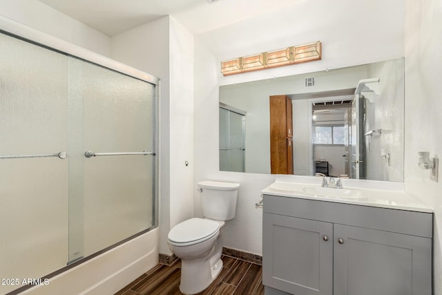 full bathroom with shower / bath combination with glass door, vanity, and toilet