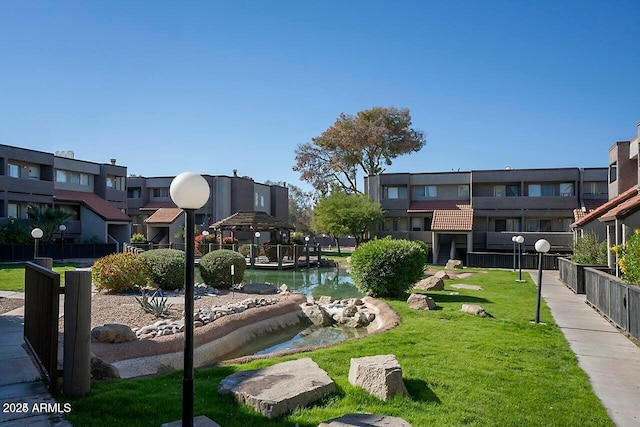 view of community with a lawn, a gazebo, and a water view