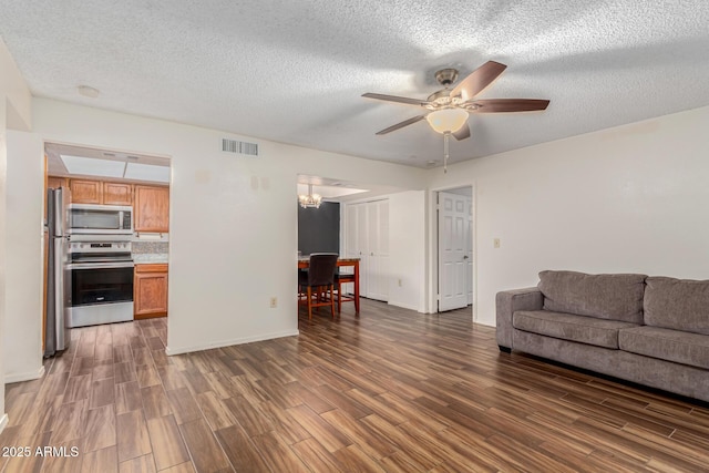 living room featuring ceiling fan, dark wood-type flooring, and a textured ceiling