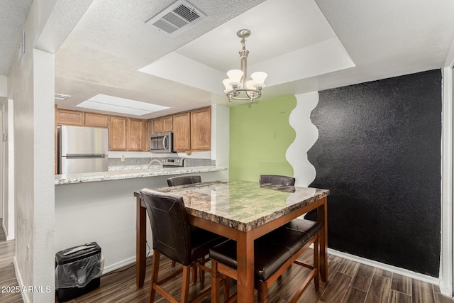 dining area featuring a tray ceiling and a chandelier