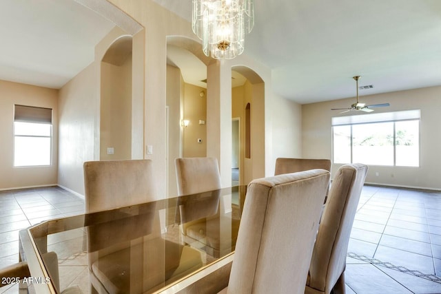 11664 W Eagle Ct, Surprise, AZ 85378 - tiled dining space featuring arched walkways, ceiling fan with notable chandelier, visible vents, and a wealth of natural light