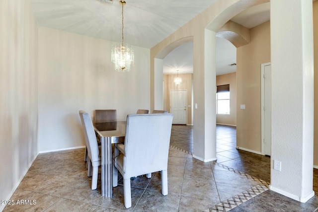 11664 W Eagle Ct, Surprise, AZ 85378 - dining area with arched walkways, tile patterned flooring, baseboards, and a notable chandelier