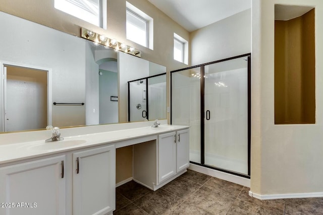 11664 W Eagle Ct, Surprise, AZ 85378 - full bathroom with tile patterned floors, double vanity, a sink, baseboards, and a stall shower