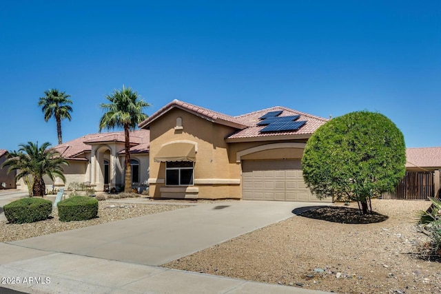 11664 W Eagle Ct, Surprise, AZ 85378 - mediterranean / spanish house featuring an attached garage, driveway, roof mounted solar panels, and stucco siding