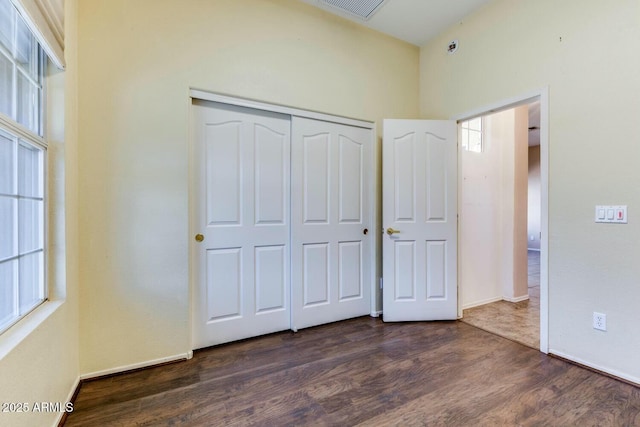 11664 W Eagle Ct, Surprise, AZ 85378 - unfurnished bedroom featuring dark wood-type flooring, a closet, baseboards, and visible vents