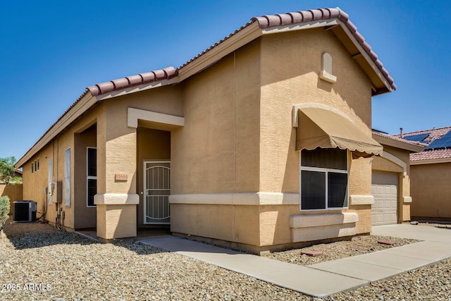 11664 W Eagle Ct, Surprise, AZ 85378 - exterior space featuring a garage, central air condition unit, a tile roof, and stucco siding