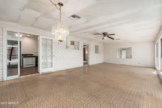 2002 W Whitton Ave, Phoenix, AZ 85015 - unfurnished room with a ceiling fan, brick wall, and a chandelier