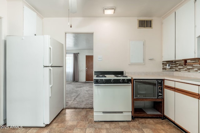 2002 W Whitton Ave, Phoenix, AZ 85015 - kitchen with white appliances, light countertops, light colored carpet, white cabinetry, and backsplash